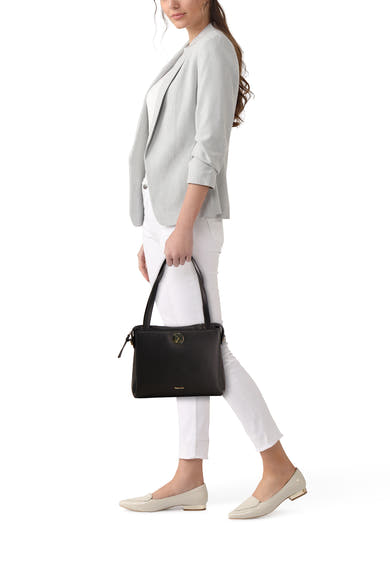 Zwarte handtas van TAMARIS, gedragen met een grijze blazer, een witte broek en beige loafers.