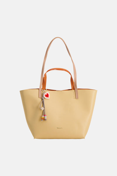 Sac à main jaune de TAMARIS avec bretelles beiges et orange et breloque décorative en forme de cœur.