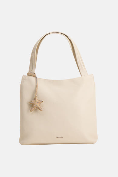 Beige handtas van Tamaris, met een sterbedel, gedragen met een zwarte trui en een zwarte broek.
