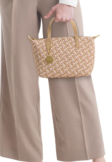 Sac à main multicolore de TAMARIS, tissé rose et beige avec un charm doré, porté avec un pantalon taupe.