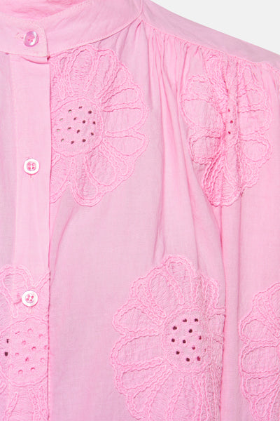 Chemisier rose à manches longues de Terra di Siena avec broderie florale ajourée et patte de boutonnage.
