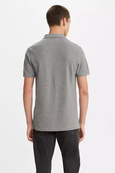 Polo gris à manches courtes de Levi's, vu de dos, porté avec un jean noir délavé.