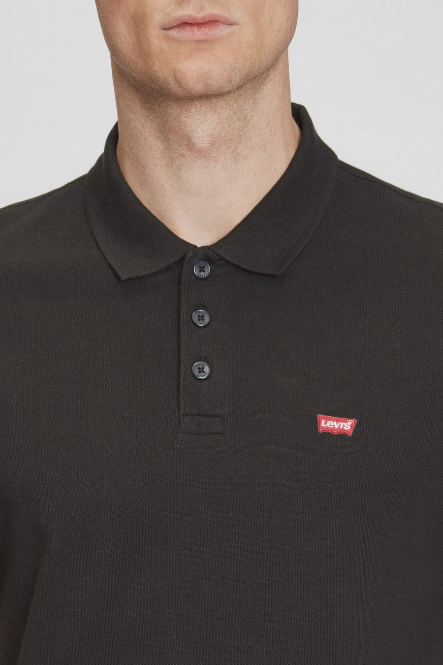 Polo noir à manches courtes de Levi's, avec logo rouge sur la poitrine et patte de boutonnage à trois boutons.