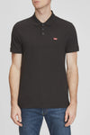 Polo à manches courtes noir de Levi's, avec un logo rouge distinctif, porté avec un jean bleu.

