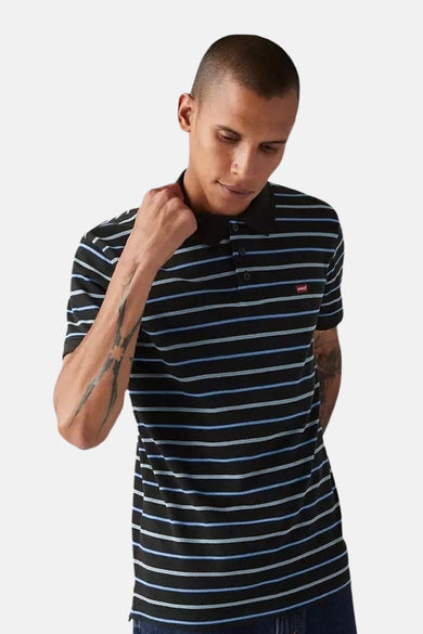 Blauwe korte mouw polo van Levi's® met zwarte, blauwe en witte strepen, gedragen met een ruwe jeans.