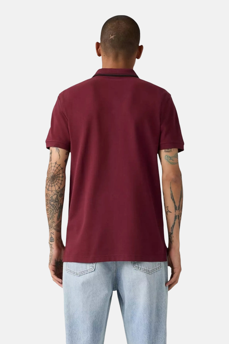 Bordeaux short-sleeve polo shirt back view with black collar trim, worn with light blue jeans