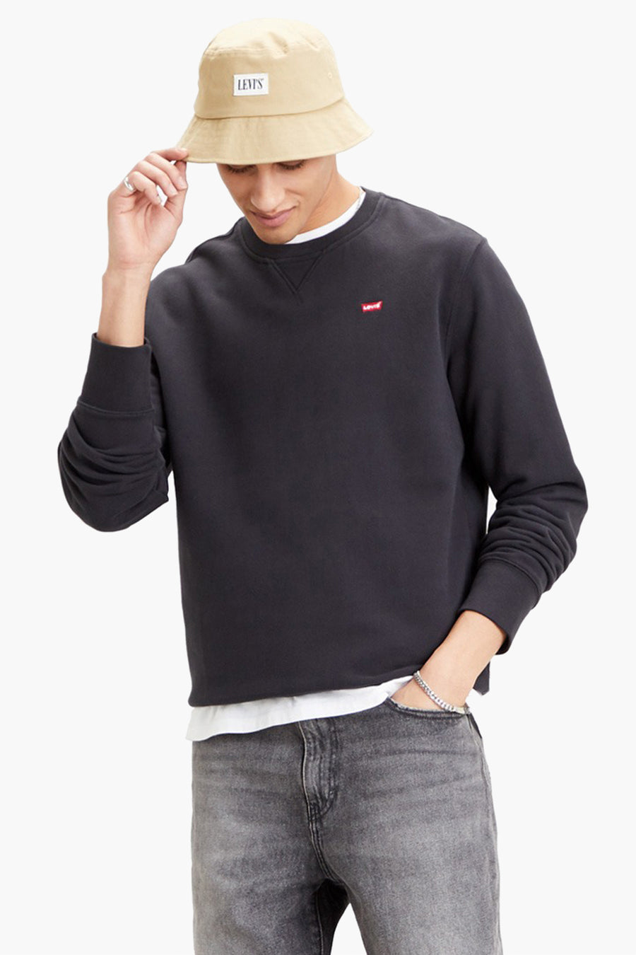 Sweat noir de Levi's®, porté avec un jean gris et un bob beige.