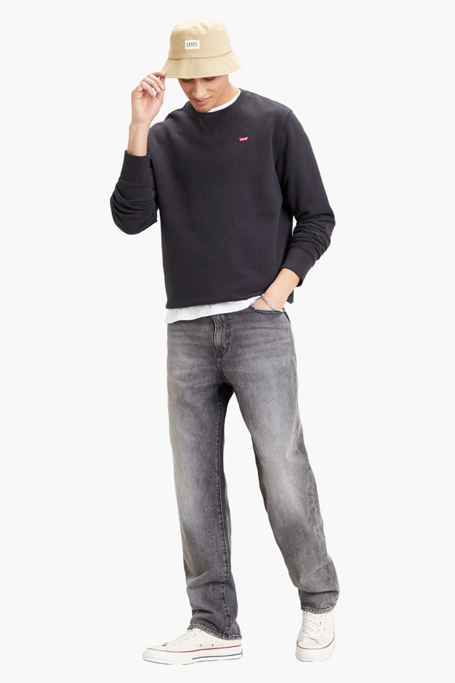 Sweat noir de Levi's, porté avec un jean gris délavé, un t-shirt blanc et un bob beige.
