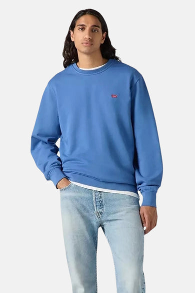 Sweat bleu par Levi's, porté avec un t-shirt blanc à col rond et un jean clair