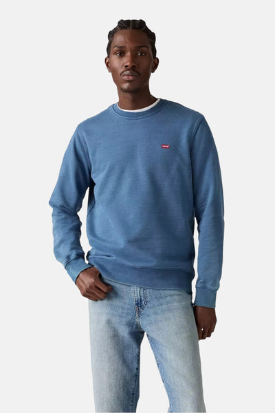Blauwe sweater van Levi's, met een klein rood logo op de borst, gedragen met een lichte spijkerbroek.