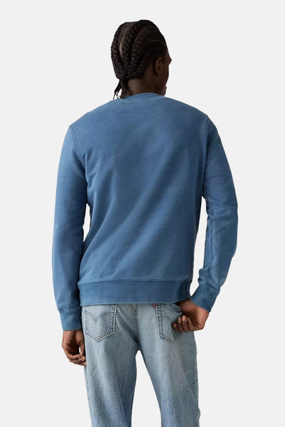 Blauwe Levi's sweatshirt, achterkant, gedragen met een licht uitgewassen spijkerbroek.