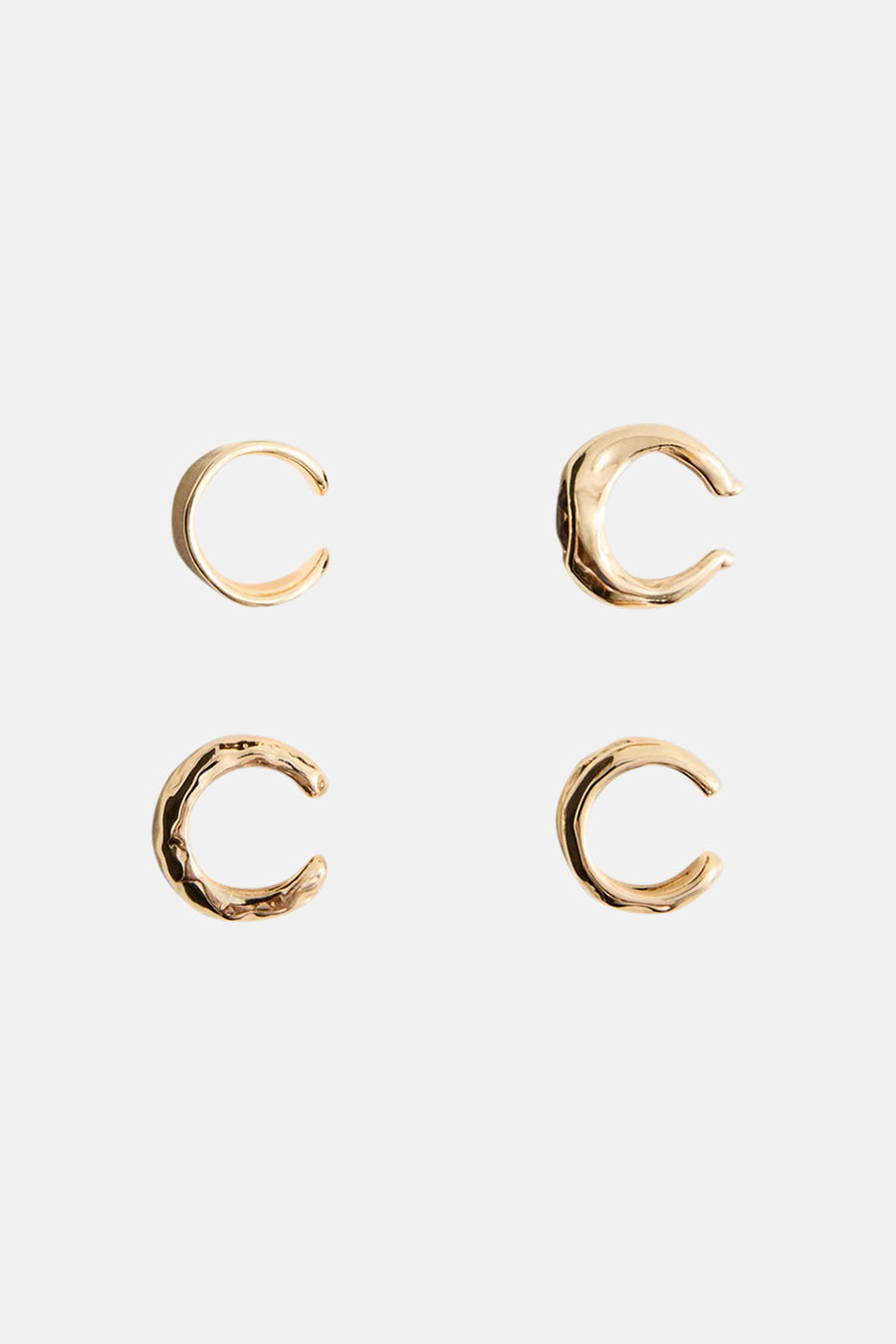 Gold-tone C-shaped hoop earrings with textured and smooth finishes, displayed in a flat lay arrangement.