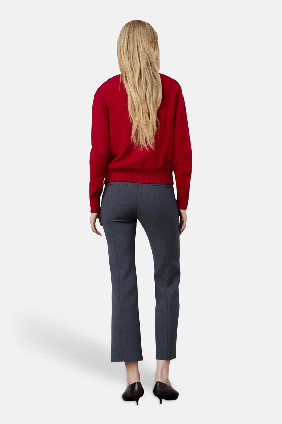 Pull col V rouge de MANGO, vue dos, porté avec un pantalon gris et des escarpins noirs