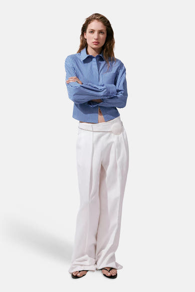Multicolored long-sleeve striped blouse with button-down front and chest pocket, worn with white wide-leg pants and black sandals in full-length lifestyle view