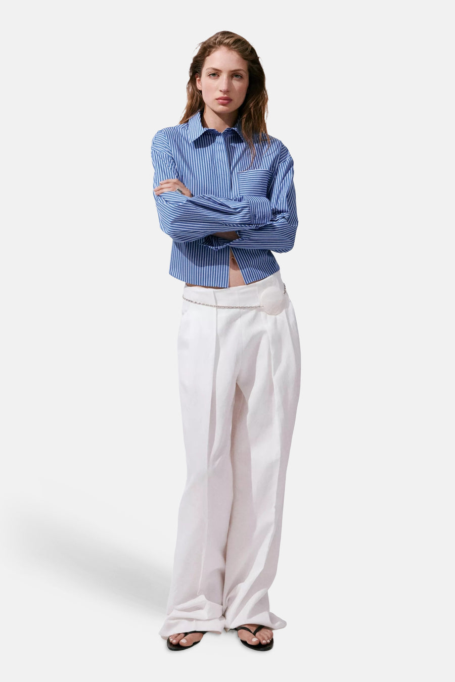 Multicolored long-sleeve striped blouse with button-down front and chest pocket, worn with white wide-leg pants and black sandals in full-length lifestyle view