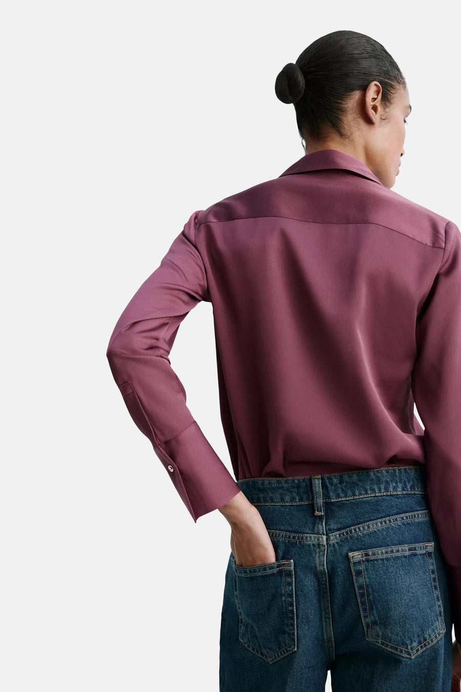 Bordeaux long-sleeve blouse with smooth satin finish, back view, paired with dark denim jeans