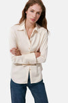 Ecru long-sleeve blouse with pointed collar and gold buttons, worn with dark blue jeans, front view