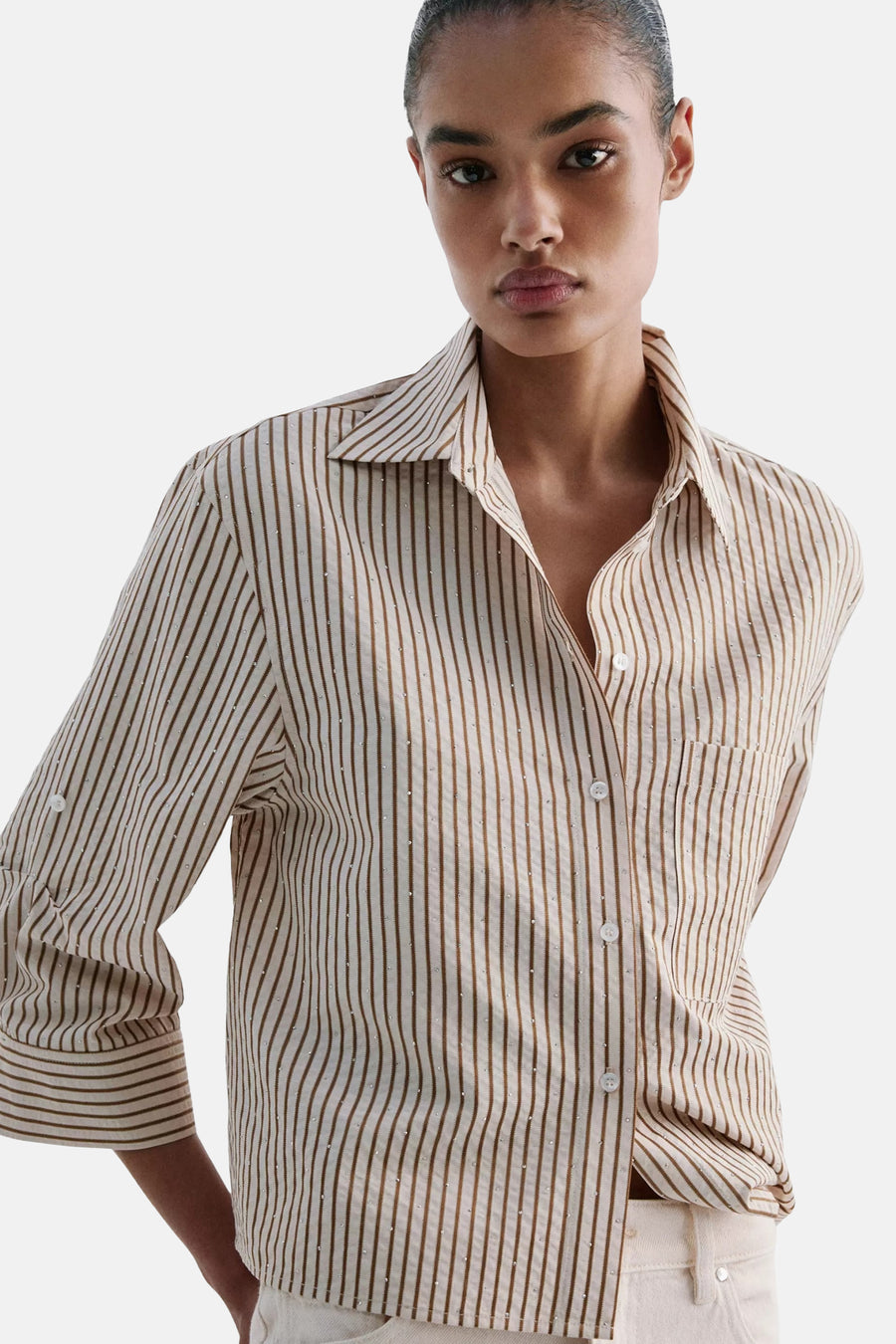 Multicolored short-sleeve blouse with vertical stripes and subtle embellishments, featuring a classic collar and button front, shown in lifestyle view.