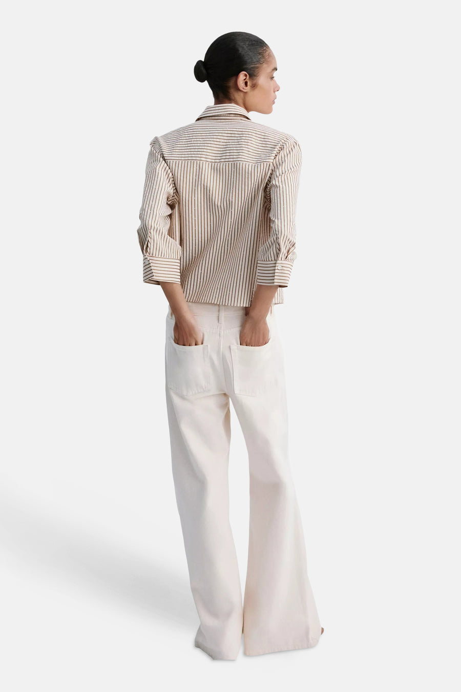 Multicolored short-sleeve blouse with vertical stripes and ruffled shoulders, back view, worn with white wide-leg pants