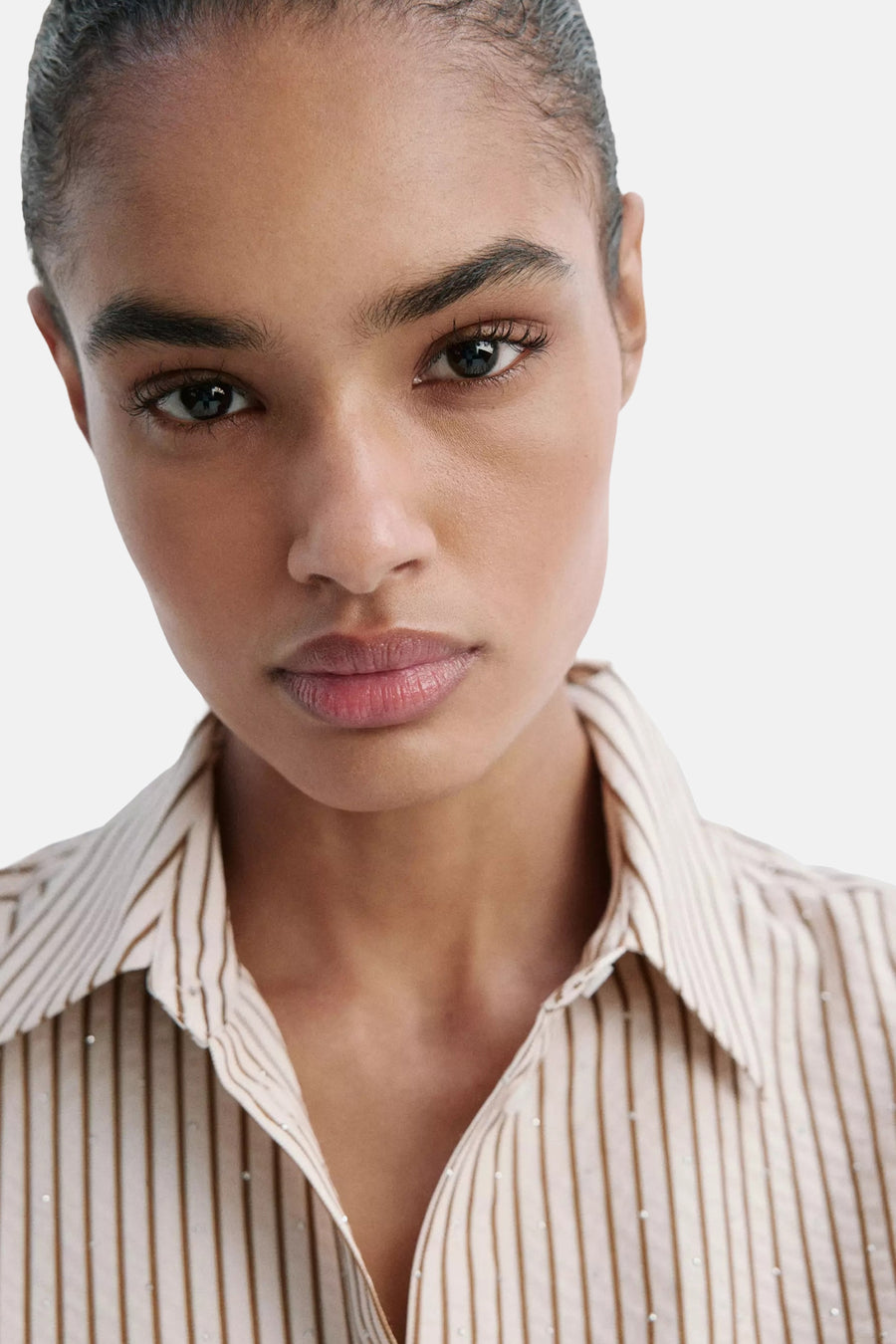 Multicolored short-sleeve blouse with vertical stripes and small white dots, cropped front view showing collar and neckline.