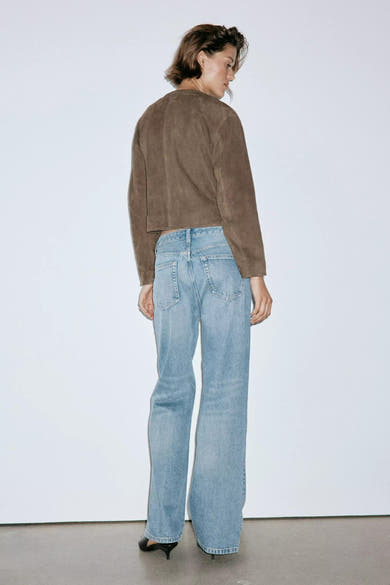 Jeans droit en denim bleu clair par MANGO, vue arrière, coupe droite avec poches carrées, portés avec un top marron et escarpins noirs.