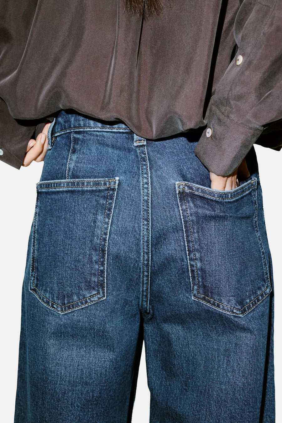Dark blue denim wide-leg jeans by CATHERIN, back view with classic stitching and large pockets, worn with a dark gray button-up shirt.