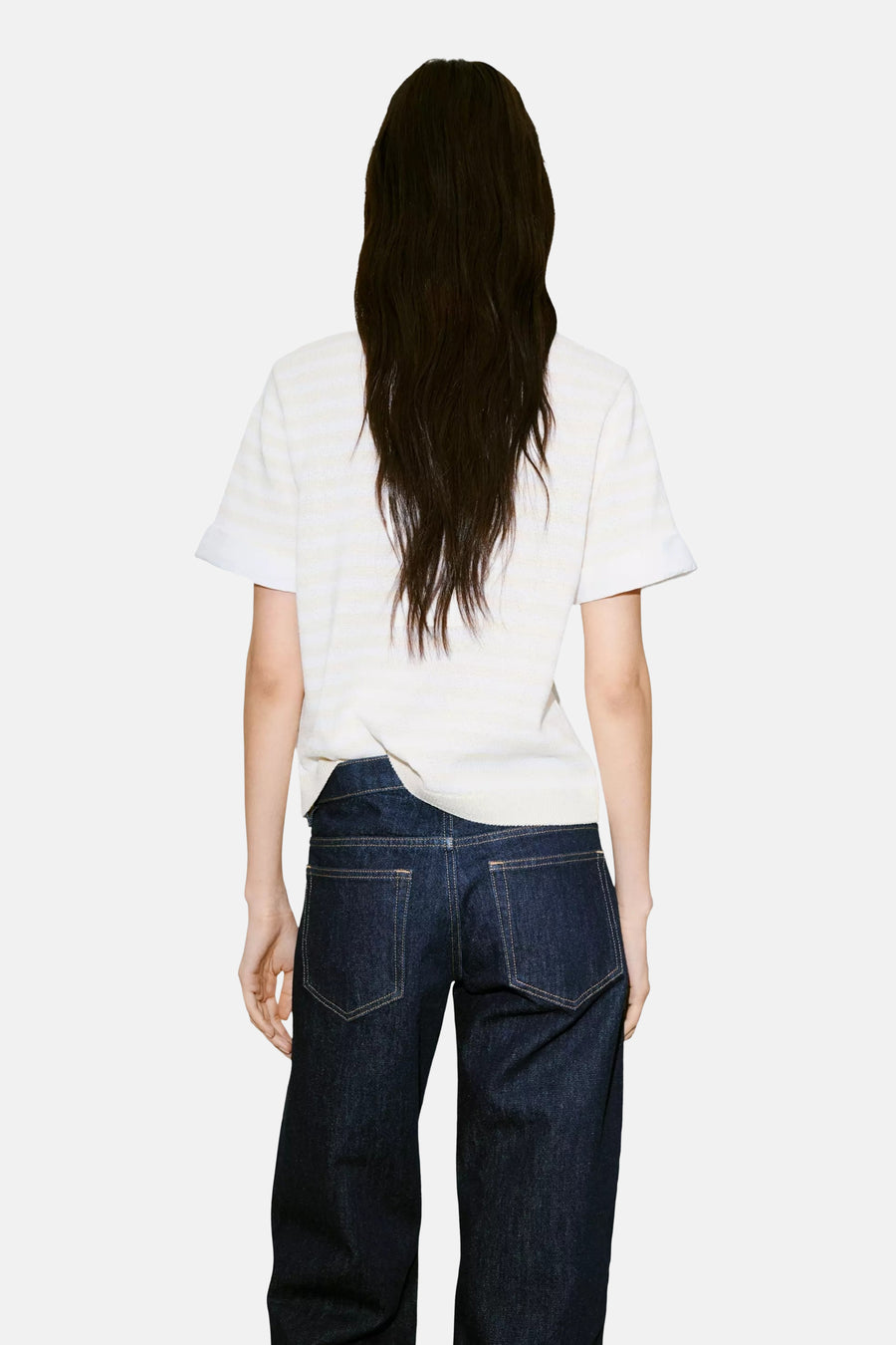 Ecru short-sleeve knit top with subtle horizontal ribbing, back view, paired with dark denim jeans