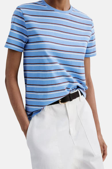 Multicolored short-sleeve t-shirt with blue base and brown-white stripes, worn with white pants and black belt, front view