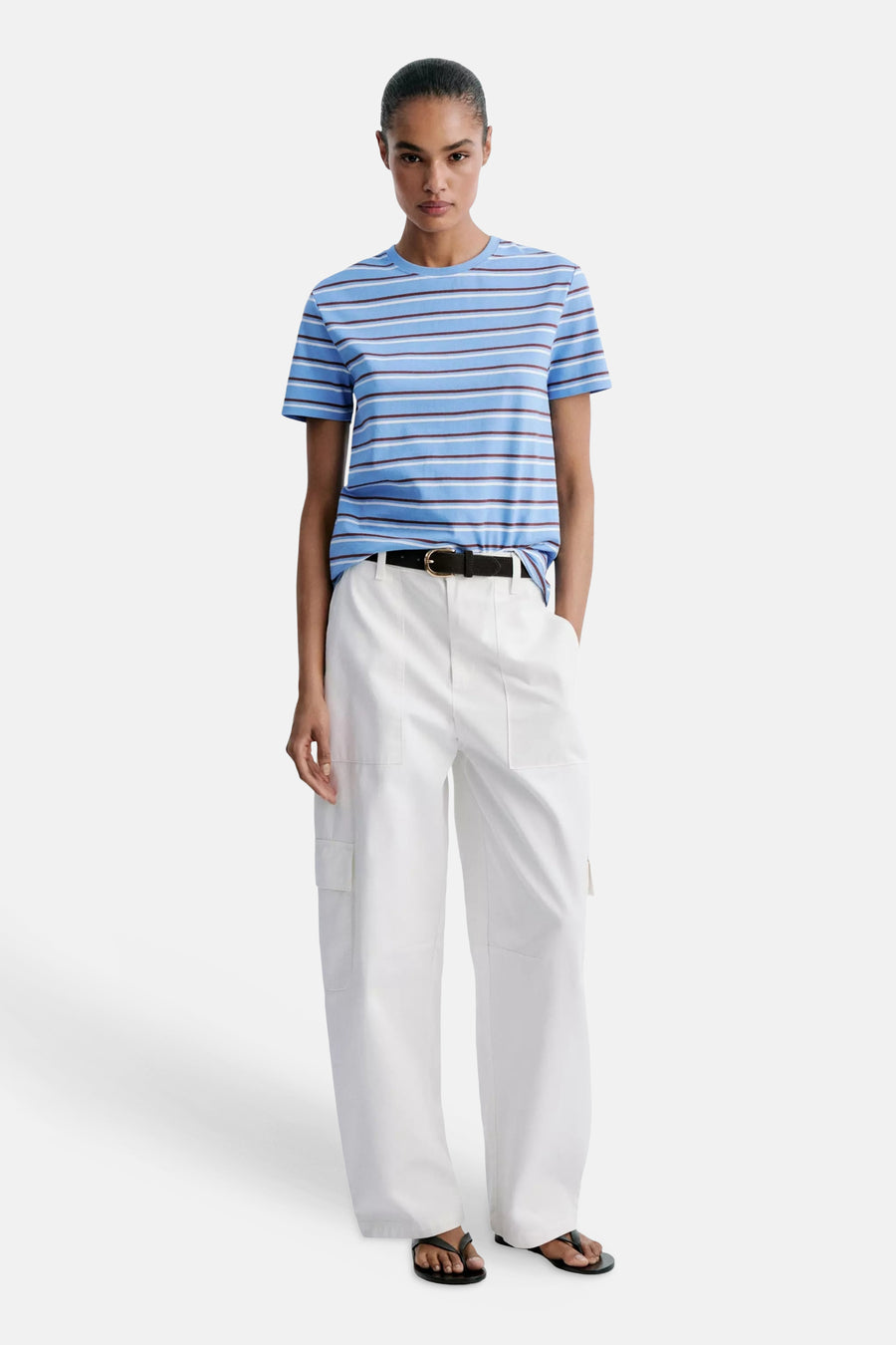 Multicolored short-sleeve striped t-shirt with blue, white, and brown horizontal bands, worn with white cargo pants and black belt in full-length lifestyle view