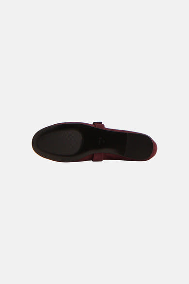 Bordeaux suede ballerina shoe from above, featuring a black sole with textured grip and a single strap across the instep.