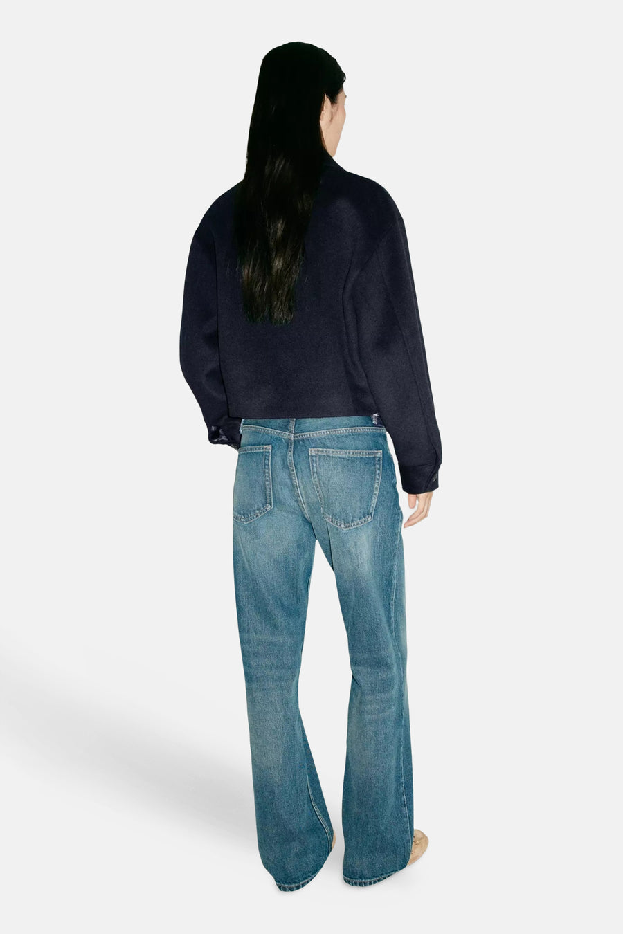Veste bleu marine ample vue dos par MANGO, portée avec jeans délavés et bottines claires