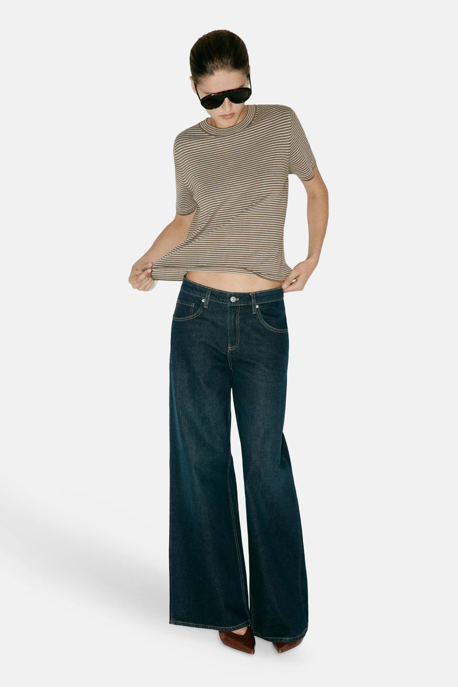 Kaki short-sleeve striped ribbed knit top with round neckline, worn with dark blue flared jeans and brown pointed-toe shoes, full-length lifestyle view