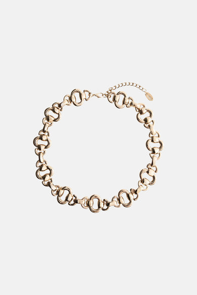 Gold-toned chunky link necklace with interlocking oval and bar chains, featuring a lobster clasp and small branded tag, shown in flat lay view.