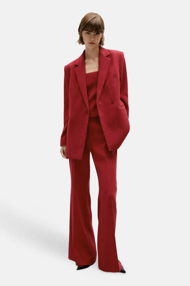 Rouge blazer with structured shoulders and single-button front, worn with matching trousers and black pointed-toe shoes, full-length front view
