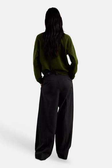 Cardigan vert en maille douce de MANGO, vue dos, porté avec un pantalon noir large