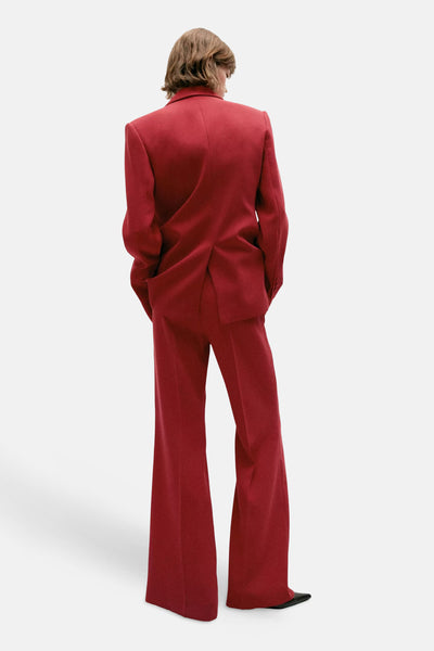 Red wide-leg suit trousers from back view, matching blazer, black shoes, smooth textured fabric, full-length fit