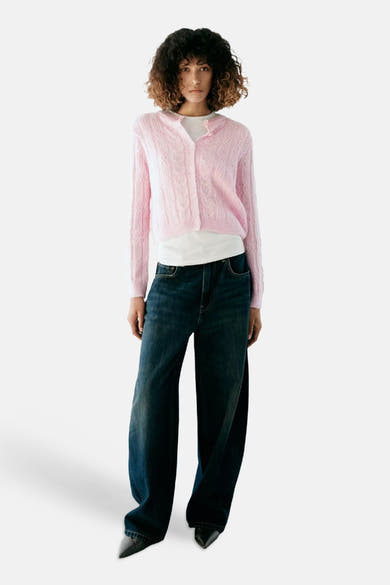 Gilet rose en maille côtelée par MANGO, porté avec un t-shirt blanc et un jean large, vue de face.
