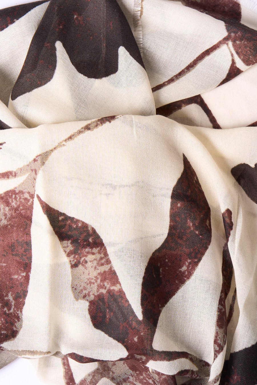 Multicolored foulard with abstract leaf pattern in cream, brown, and burgundy, soft lightweight fabric, close-up view