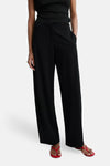 Black wide-leg elastic waist trousers with lace trim at waist, worn with black top and red flip-flops, front view