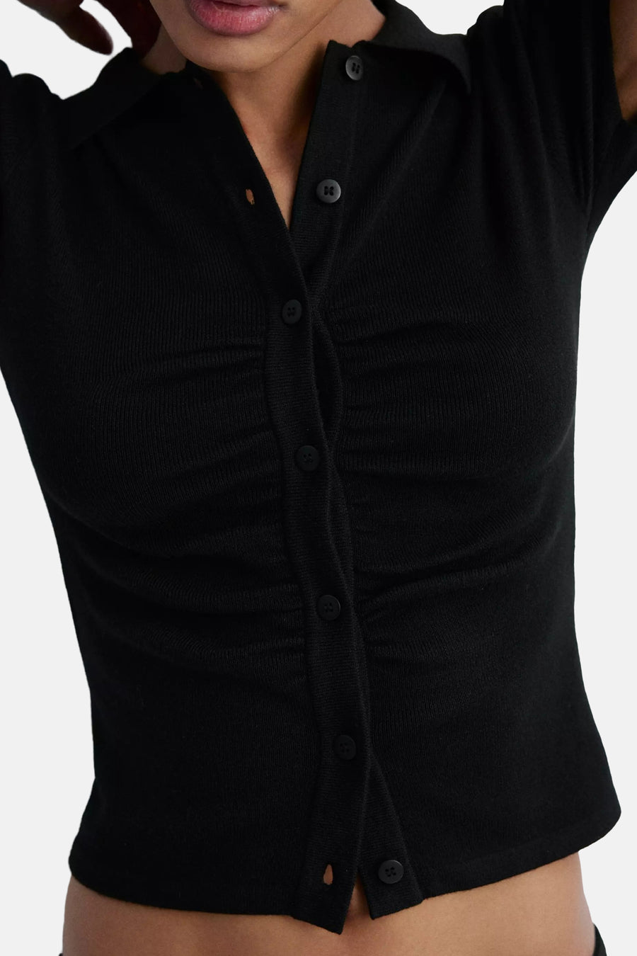 Black ribbed knit cardigan with front buttons and ruched detailing, cropped fit, close-up view