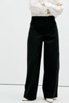 Pantalon cargo noir ample par MANGO, vue de face, porté avec chemise blanche et chaussures claires