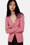 Rose ribbed knit cardigan with V-neck and matching buttons, worn by model with arms crossed, front view