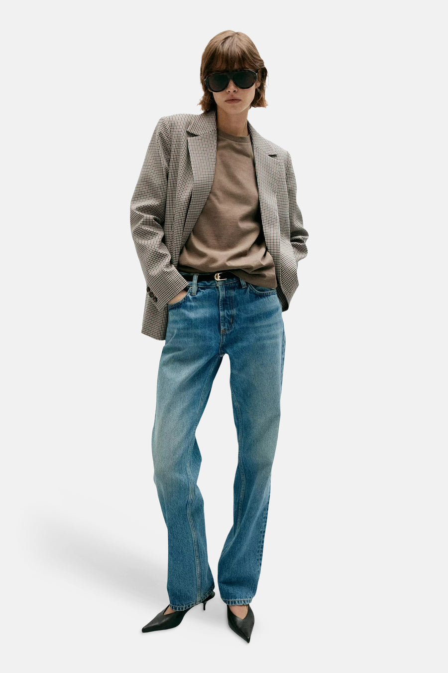 Multicolored houndstooth blazer with structured shoulders, worn open over olive tee and blue jeans, full-length front view.