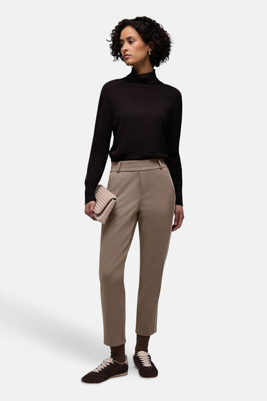 Pantalon beige élastique pour femmes de STREET ONE, avec des baskets marron et un sac à main tressé.
