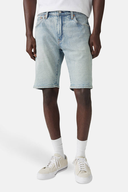 Short en denim bleu clair de Levi's®, porté avec des chaussettes et des chaussures de sport blanches.
