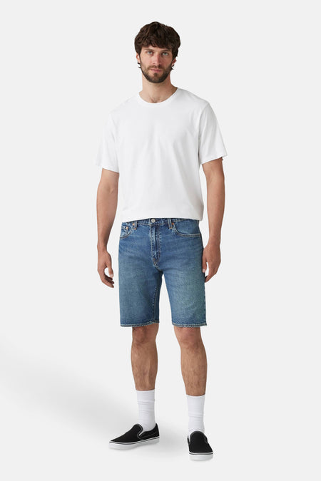 Short en denim bleu moyen de Levi's®, porté avec un t-shirt blanc uni, des chaussettes blanches et des chaussures noires.
