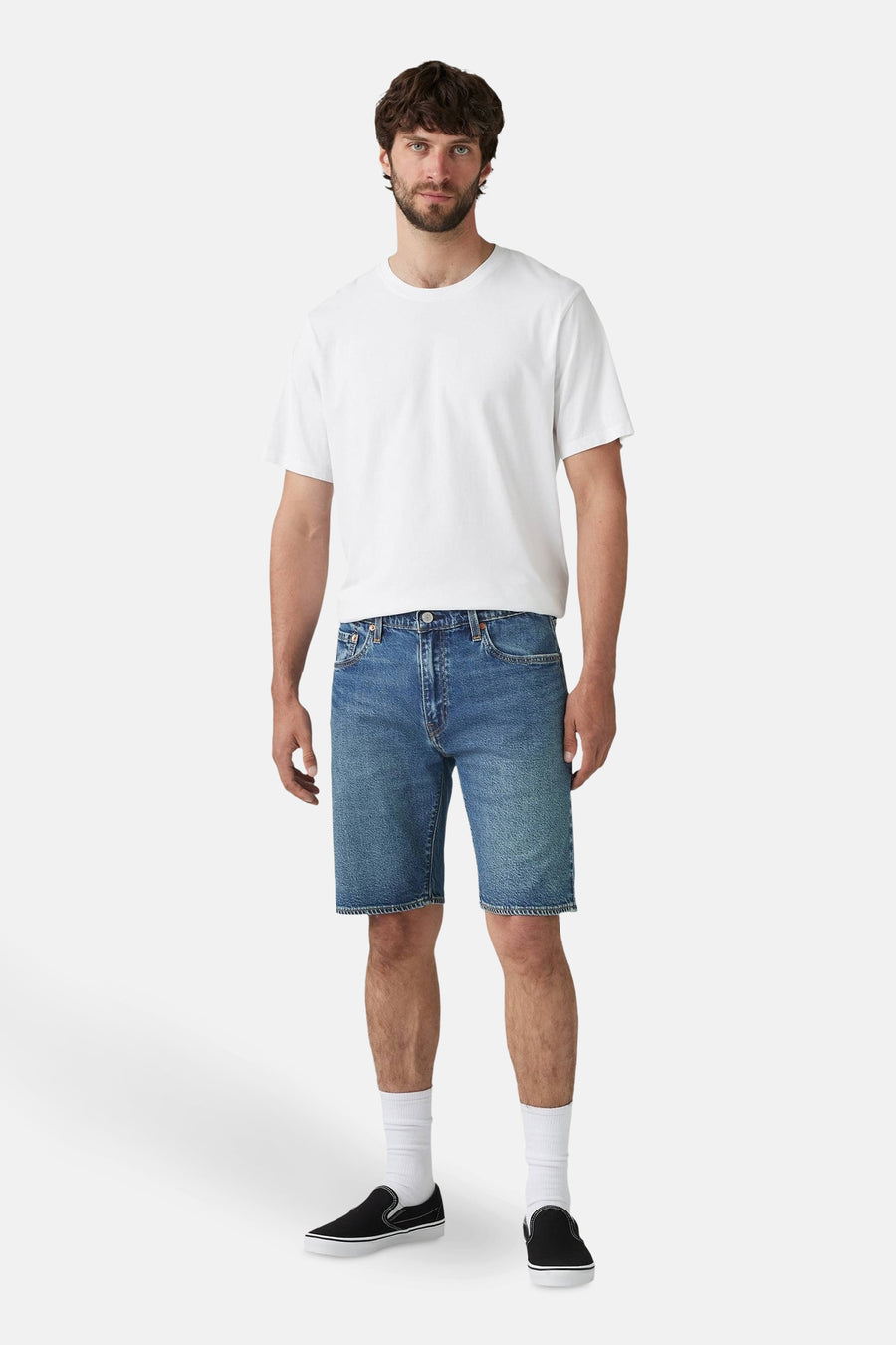 Short en denim bleu moyen de Levi's®, porté avec un t-shirt blanc uni, des chaussettes blanches et des chaussures noires.
