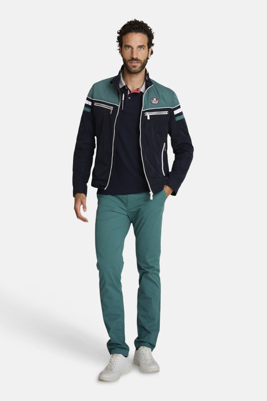 Blauwe blazer voor heren van DELAHAYE, gedragen met een marineblauwe polo, een groene broek en witte sneakers.