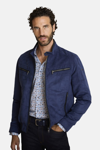 Veste courte bleu marine en suédine de DELAHAYE, avec poches zippées, portée sur une chemise à motifs floraux.