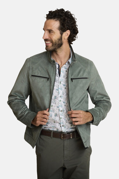 Veste courte verte par DELAHAYE, détails matelassés aux épaules, portée avec une chemise à imprimé floral et un pantalon vert olive.